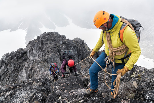 Greenland, Sermersooq, Kulusuk, Schweizerland Alps, mountaineers with rope ascending rocky mountain