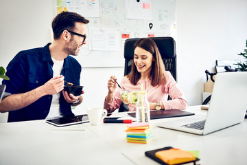 Two colleagues talking during lunch break in office