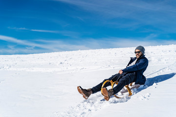Fototapeta na wymiar Germany, Bavaria, Brauneck, man sledging in winter in the mountains