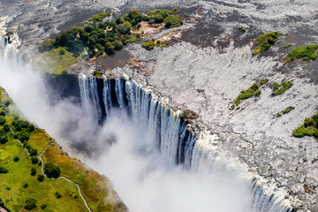 Victoria Falls from aerial view. Waterfall in southern Africa on the Zambezi River at the border between Zambia and Zimbabwe. Rainbow on the river. 