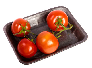 ripe red tomatoes in a dark plastic tray. on a white background