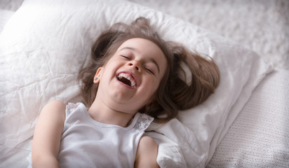Fototapeta premium Little cute girl smiling in bed , sleep concept