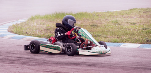 Child drives in go-kart on track during competition
