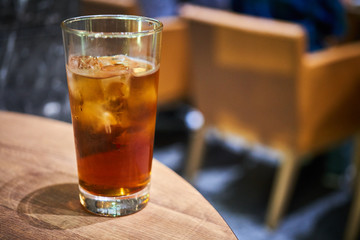 丸いテーブルの上に置かれたお茶と氷の入ったグラス