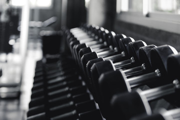 Background view back and white equipment dumbbells on rack in the gym sport center