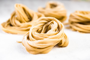 Italian spaghetti raw pasta on white marble table