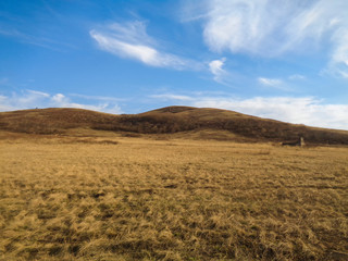 Spring steppe landscape. Landscape in Kazakhstan. Kazakh steppe. Hills. Blue sky. Yellow grass