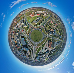Aerial 360 angle panoramic little planet view on roundabout junction in medium city with traffic
