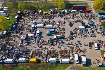 Aerial view on flea market with miscellaneous items and crowds of buyers and seller's makeshift...