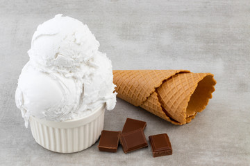 plate of vanilla ice cream scoops, and chocolate pieces and waffle cones