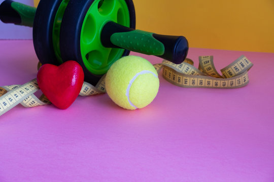 Sports items and figures of hearts lie on a pink background. Love of sport