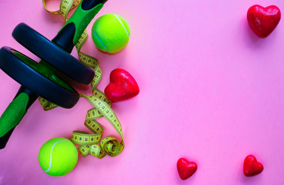 Sports items and figures of hearts lie on a pink background. Love of sport