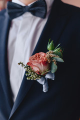 the groom holds a wedding bouquet in his hands