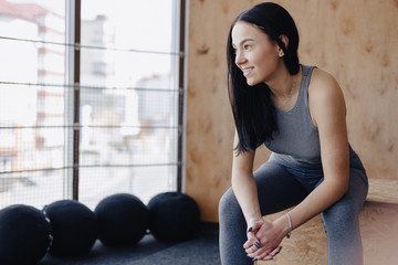 young girl in sportswear in a gym in a simple background, a theme of fitness, a crossfit and sport