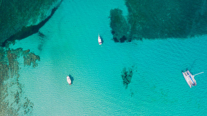 Amazing drone aerial landscape of the charming area of Es Trencs and the boats with a turquoise sea. It has earned the reputation of Caribbean beach of Mallorca. Spain