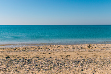 Fototapeta na wymiar sandy pebble beach of the beautiful turquoise sea