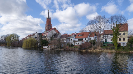 Fototapeta na wymiar Sankt-Marien-Andreas-Kirche im alten Hafen der Stadt Rathenow im Havelland vor blauem Himmel mit Wolken 