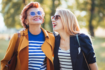 Mature mother and adult daughter enjoying a day in the park