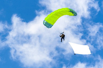 Bright parachutist on the background of blue sky.