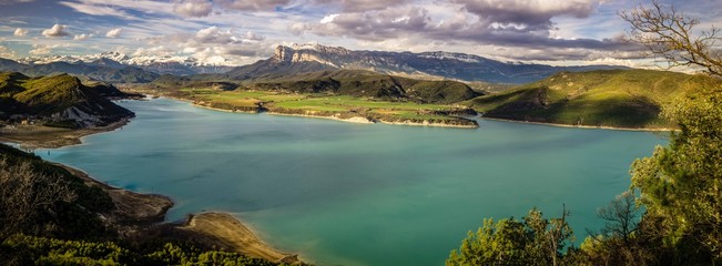 Vista panorámica de un pantano con los montes Pirineos al fondo