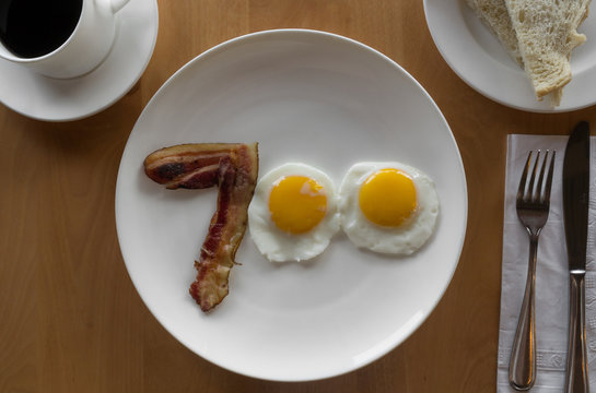 fried egg and bacon on a plate in the shape of the number 700