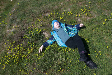 Boy lying on his back in meadow