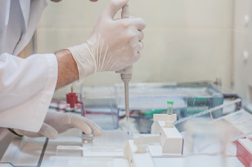 Scientist dropping blood into test-tubes
