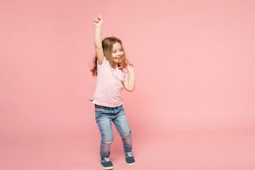 Little cute child kid baby girl 3-4 years old wearing light clothes dancing isolated on pastel pink...