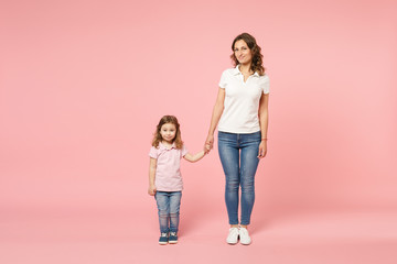 Woman in light clothes have fun with cute child baby girl. Mother, little kid daughter isolated on pastel pink wall background, studio portrait. Mother's Day, love family, parenthood childhood concept