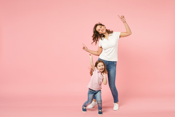 Woman in light clothes have fun with cute child baby girl. Mother, little kid daughter isolated on pastel pink wall background, studio portrait. Mother's Day, love family, parenthood childhood concept