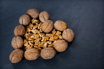 walnut on a gray background in the shape of a heart to the side