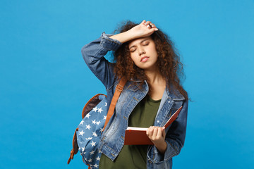 Young african american girl teen student in denim clothes, backpack hold books isolated on blue wall background studio portrait. Education in high school university college concept. Mock up copy space