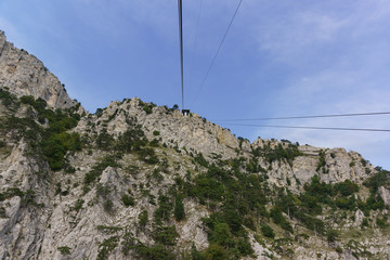 Ropes tourist suspension lift climb to the top of the high Crimean mountain AI-Petri. The rocks are beautifully overgrown with pine trees