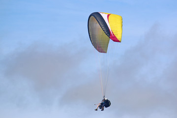 Tandem paraglider flying yellow wing