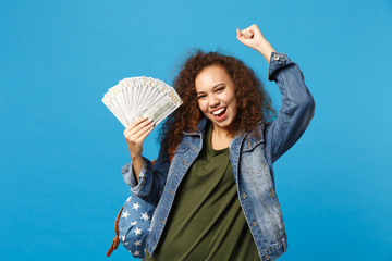 Young african american girl teen student in denim clothes, backpack hold cash money isolated on...