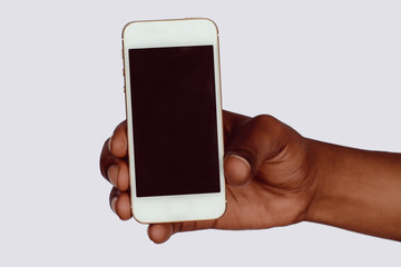 Male hand holding smartphone with blank screen.