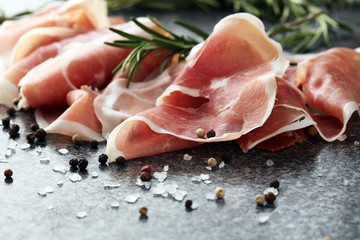 Italian prosciutto crudo or jamon with rosemary. Raw ham with spices - obrazy, fototapety, plakaty
