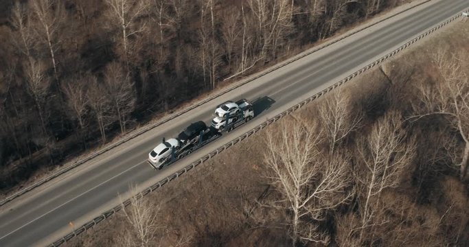 Auto transporter driving on bridge / traveling on highway aerial footage at spring time / top view / Highway truck traffic
