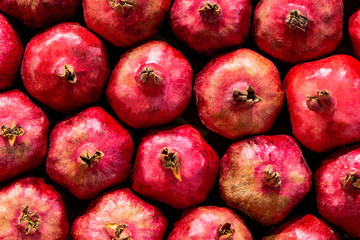 Rows Of Pomegranates. Garnets Closeup, Background. Group Of Ripe Pomegranates Fruits Neatly Laid Out On Counter In Store.