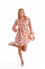 Beautiful young blonde woman in pink polka dot dress isolated on white background