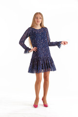 Fototapeta premium Beautiful young blonde woman in dark blue dress with floral print isolated on white background