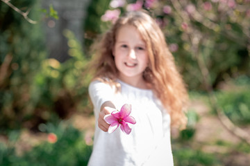 Naklejka premium beautiful purple flower close up. magnolia tree in blossom. Adorable girl smile in park with blossoming flowers. selective focus