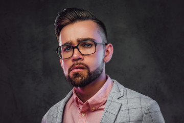 Portrait of sceptical proud man in checkered  blazer, pink shirt and glasses.