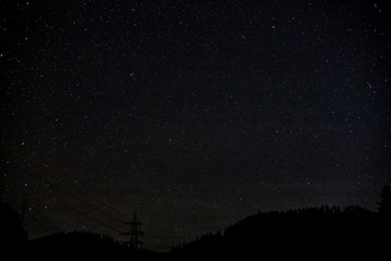 night sky milky way with billion stars and tree and power line silhouette