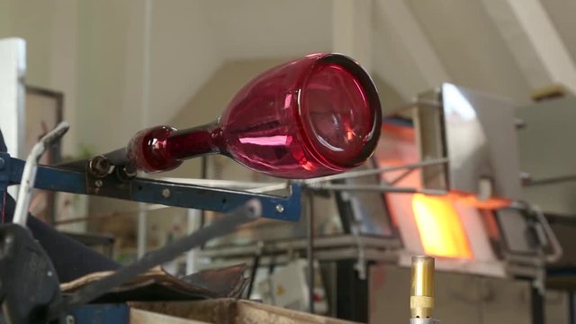 Glassblowing Professional Working on Torch Flame with Glass Tubes. Glass blower forming beautiful piece of glass. A glass crafter is burning and blowing an art piece.