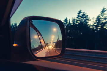 Night highway in the side mirror while driving - photo, image. Soft focus