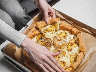 Obraz na płótnie Canvas Pizza with pear and dor blue cheese in delivery box. Female hands