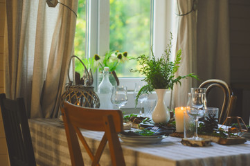 cozy evening family dinner in rustic style. Table summer setting in natural style with wild ferns...