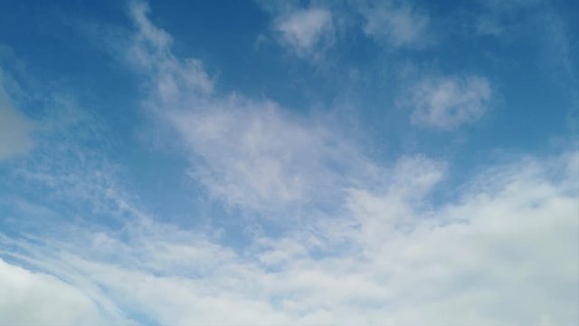 Timelapse with clouds rolls with awe movement , puffs of color smoke and plays of light in a blue sky
