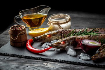 Russian cuisine. pike with spices on an old wooden background. fish with spices for cooking. top view, space for text